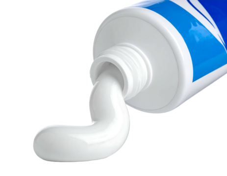 Close-up white paste extruded from a tilted blue & white tube, set against a stark black background