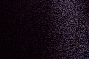 紫の光に包まれたざらざらした土壁のテクスチャー