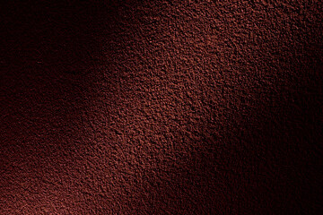 赤いライトに照らされたざらざらした土壁のテクスチャー