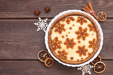 Festive Christmas holiday eggnog pie. Above view table scene on a dark wood background.