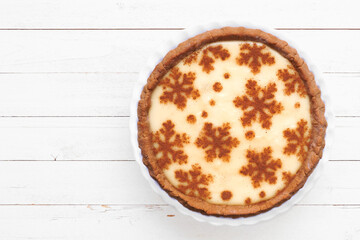 Festive Christmas holiday eggnog pie. Top view on a white wood background.