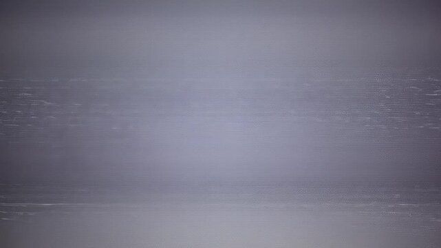 VHS-style view with overlay distortion &mdash; thick horizontal glitches smear across the frame, screen colors bleed and jitter. Flicker synced with ambient buzz and old VCR tape winding.