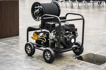 Heavy-duty industrial pressure washer with hose reel on wheels, perfect for commercial cleaning and...
