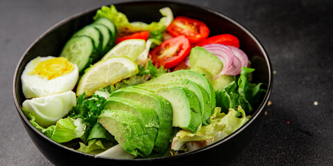 Avocado salad egg, tomato, onion, green leaf salad vegetable dish natural tasty snack fresh gourmet food background on the table rustic top view copy space keto and paleo diet vegan and vegan food