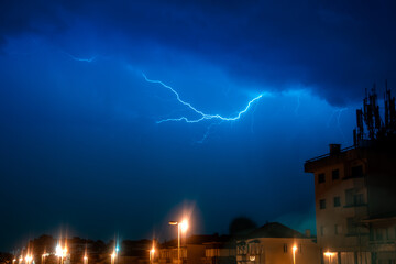 Lightning storm over quiet residential street at night