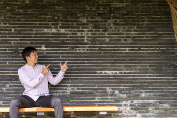 伝えたいポイントを指し示す男性ポートレート｜テキスト入れやすい背景