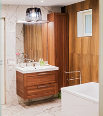 Modern bathroom interior with sink cabinet, mirror, and white bathtub. contemporary stylish home decor.