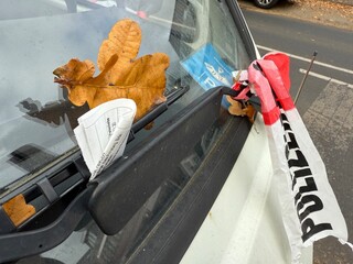 Police tape and parking ticket on car windshield concept of fine law and street control