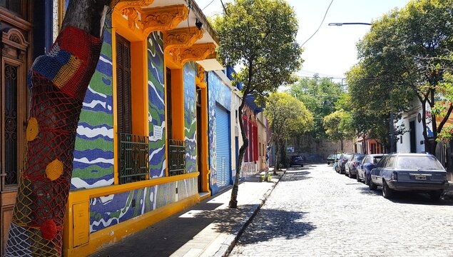 Calles empedradas con &aacute;rboles decorados por los vecionos con tejidos hechos a mano en el antiguo y tradicional barrio de Barracas en Buenos Aires, Argentina 