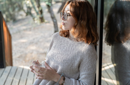 Young woman relaxing contemplating nature and drinking tea