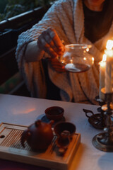 Cozy evening tea preparation with warm candlelight and tranquil ambiance