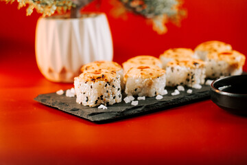 Delicious sushi platter with crispy topping served on a slate board