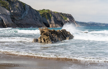 The cold Atlantic Ocean, the white foam of the waves and the golden sand of Zumaia beach