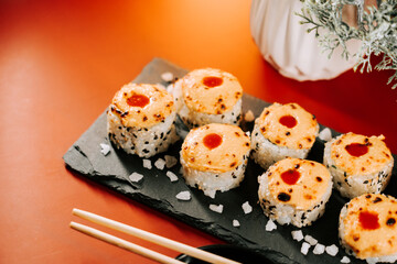 Delicious baked sushi served on a black slate plate at a modern restaurant