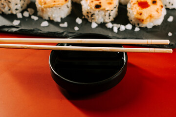 Enjoying sushi with chopsticks on a black plate at a restaurant table