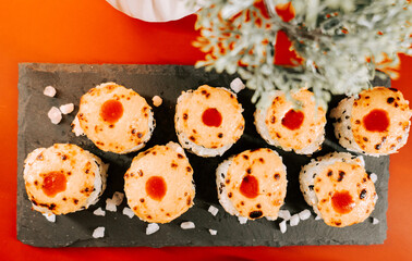 Sushi rolls served on a slate platter with garnishes in a vibrant dining setting