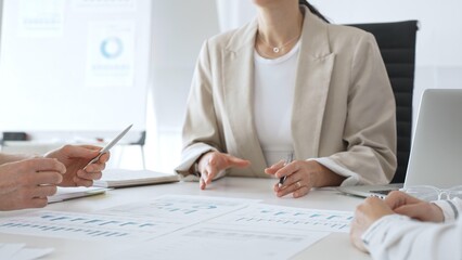 Professional team reviewing financial charts, collaborating on data analysis and strategic planning in modern corporate workspace, emphasizing teamwork and productivity