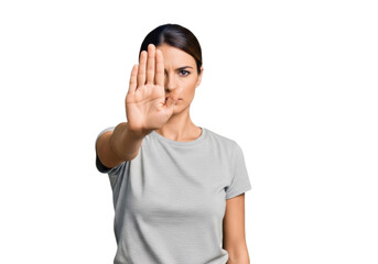 Young woman showing a ''stop'' gesture with her hand, on a transparent background, isolated