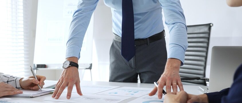 Business team analyzing financial charts and graphs during strategy meeting in modern office, focusing on corporate planning, data analysis, and decision making