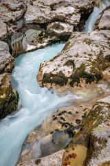 Detail view of beautiful turquoise Soca River flows through rocky landscape. This is a popular travel destination near Bovec, Slovenia.