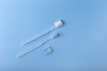 White toothbrushes from above on blue background. Oral care, gum and teeth health. Morning routine and health care.