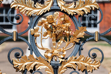 London, United Kingdom - August 13, 2022: Ornate black and gold wrought-iron gate detail at Kensington Palace
