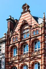 London, United Kingdom - August 13, 2022: Ornate Victorian red and beige brick building facade in the Kensington district
