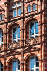 Fototapeta premium London, United Kingdom - August 13, 2022: Ornate Victorian red and beige brick building facade in the Kensington district
