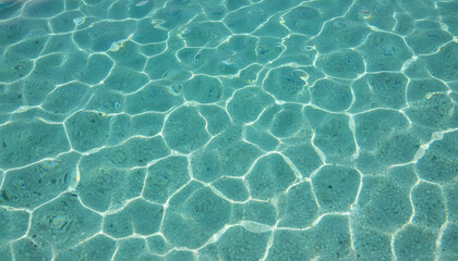 Obraz premium Sparkling Turquoise Water Surface Ripples with Sun Reflections, Ideal for Summer Vacation and Relaxing Getaway Design Projects