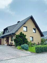 Charming suburban house with a well-kept garden and clear sky on a calm afternoon in a quiet neighborhood