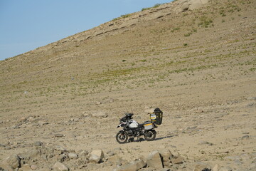 Obraz premium A motorcycle parked on a mountainside next to a lake