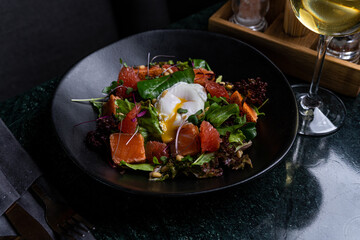 Fresh Salad with Poached Egg and Smoked Salmon in a Gourmet Setting