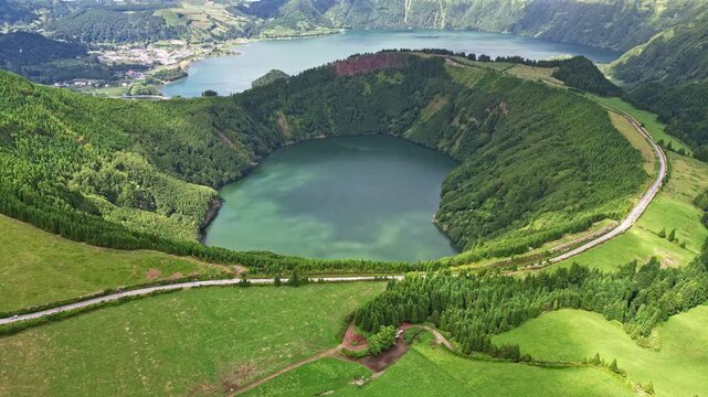 Aerial drone view of the idyllic Lagoa das Sete Cidades crater lakes. Camera shows Lagoa de Santiago lake and the road. Grota do Inferno viewpoint, Sao Miguel Island, Azores, Portugal
