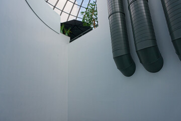 Three tall pipes by a concrete wall and a clear dome