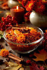 Autumnal still life with flowers, candles, and spices on a wooden table