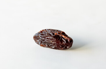 A single whole medjool date isolated against a white background.