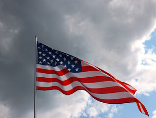 US American flag waving in stormy cloudy sky
