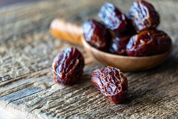 Whole medjool dates on a rustic wooden board with copy space to the left.