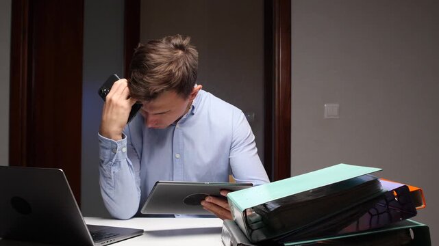 Stressed man working overtime multitasking with multiple devices