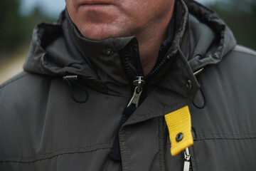 urban commuter adjusting jacket, focused shot of man fastening jacket collar in city outdoor setting © Northern life