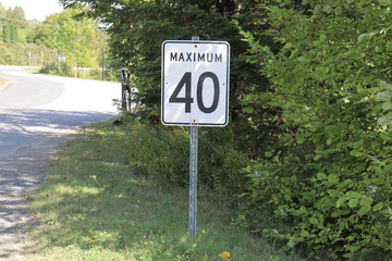 A speed limit sign, with trees. Speed limit in a rural country. Road sign illustration for information and communication. Number forty.