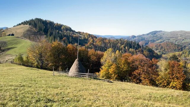 Ukraine, drone, flight in the Carpathians early in the autumn morning at sunrise near the city of Kosiv. Bright forests and dwellings of the Hutsul highlanders on the glades