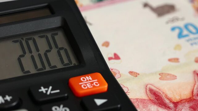 Argentina.. Fiscal year 2026. Business and economic concept. Symbol Argentine pesos. Counting money. Year 2026 displayed on calculator. Financial background. close up