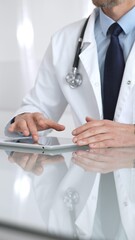 Doctor using digital tablet, consulting with patient, working in healthcare office, telemedicine and medical technology concept. Medicine and health care
