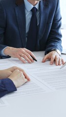 Business people colleagues reviewing contract documents during an office meeting, discussing terms,...