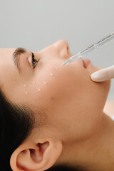 Cosmetologist is making facial mesotherapy injections for girl. Facial mesotherapy to rejuvenate...