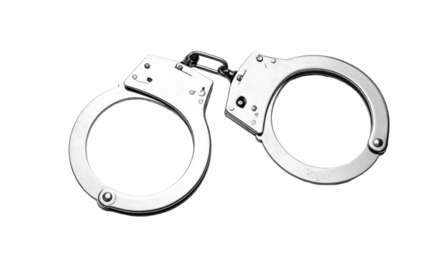 A pair of shiny metal handcuffs resting against a plain, dark background. Focus is on the metal and its curves