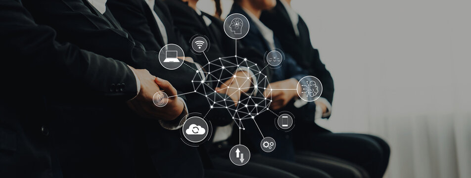 A group of business professionals dressed in suits sits attentively during a meeting. Digital icons showcase themes of technology and collaboration, illustrating modern business dynamics. Trope