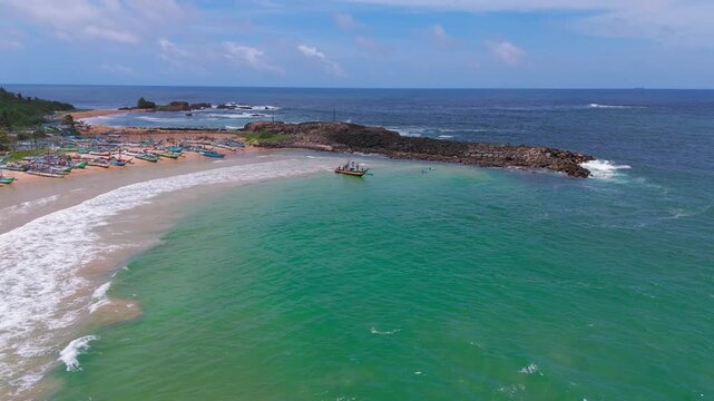 Aerial Tracking Shot of Fishing Boat Sailing From Shoreline Into Turquoise Sea