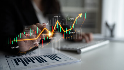 A business professional analyzes stock market trends using digital graphs and data on a computer, emphasizing financial growth in a modern office setting. Scalp